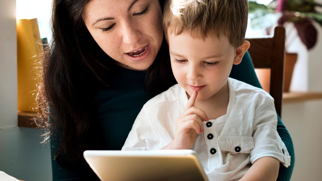 A buy and a speech therapist using a tablet